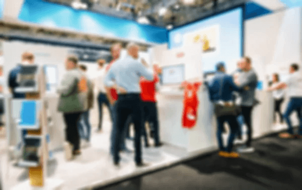 A busy exhibition hall floor with booths and attendees, generic and unbranded