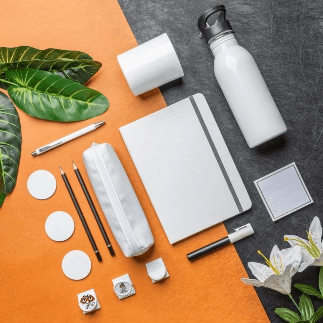 A flat-lay of branded promotional stationery in orange and charcoal tones